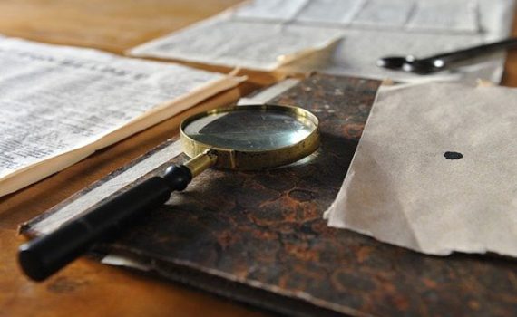 magnifying glass on papers and books